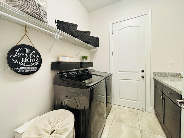 laundry area featuring light tile patterned flooring, cabinets, and washing machine and clothes dryer