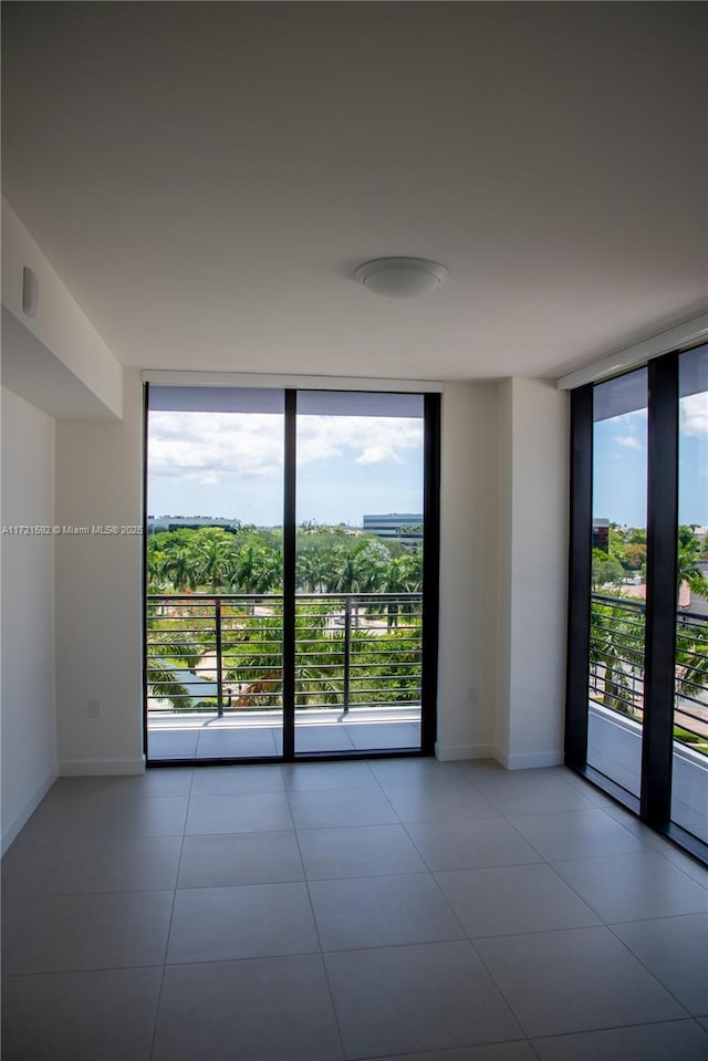 tiled empty room with floor to ceiling windows and a healthy amount of sunlight