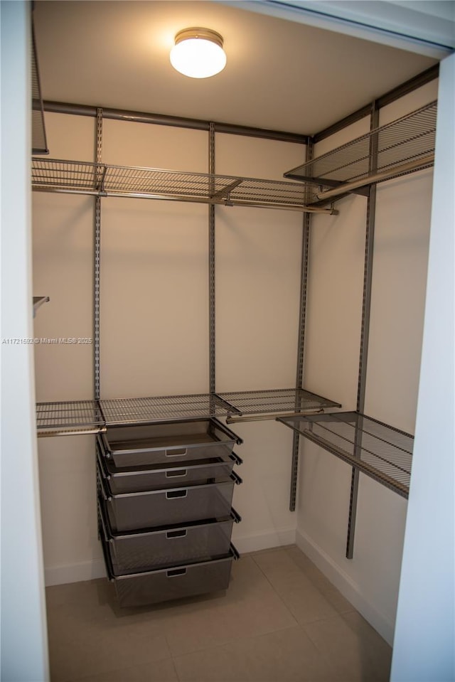 walk in closet with light tile patterned floors