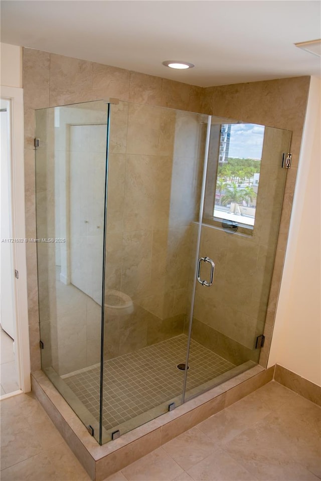 bathroom featuring tile patterned floors and a shower with shower door