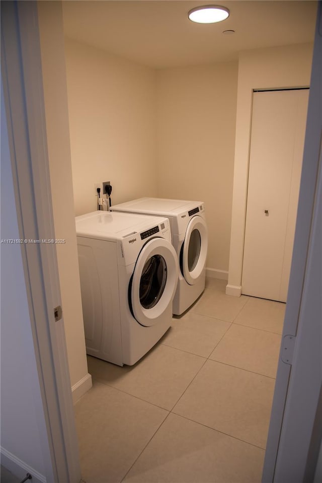 laundry area featuring separate washer and dryer and light tile patterned floors