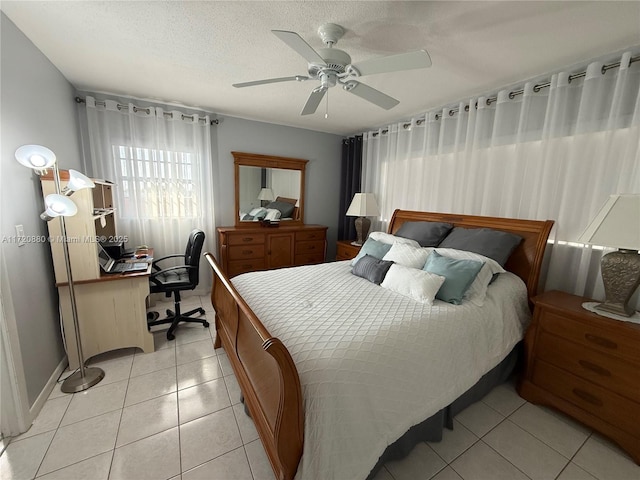 tiled bedroom featuring ceiling fan and a textured ceiling