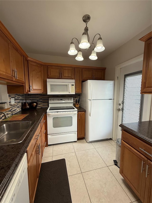 kitchen featuring pendant lighting, white appliances, sink, and light tile patterned floors