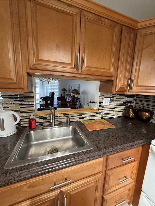 kitchen featuring stove, sink, and tasteful backsplash