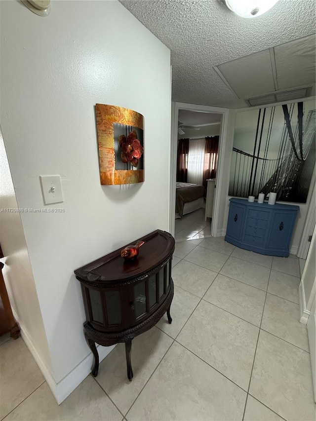 hallway with light tile patterned floors and a textured ceiling