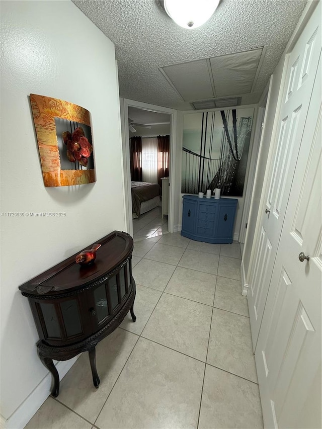 hall with light tile patterned floors and a textured ceiling