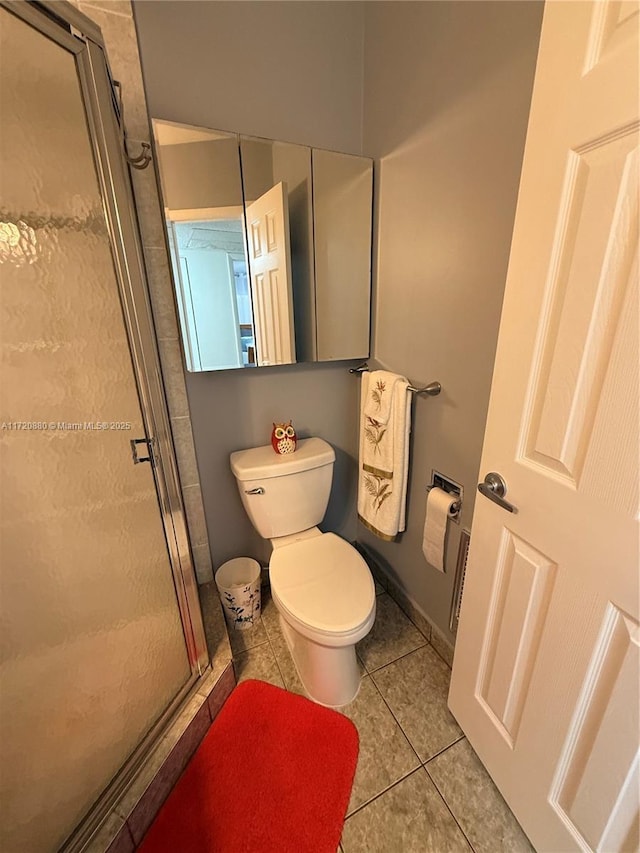 bathroom with toilet, tile patterned floors, and an enclosed shower