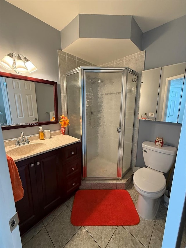 bathroom featuring tile patterned flooring, vanity, an enclosed shower, and toilet