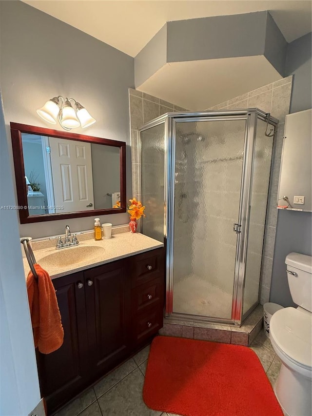 bathroom with tile patterned floors, vanity, toilet, and an enclosed shower