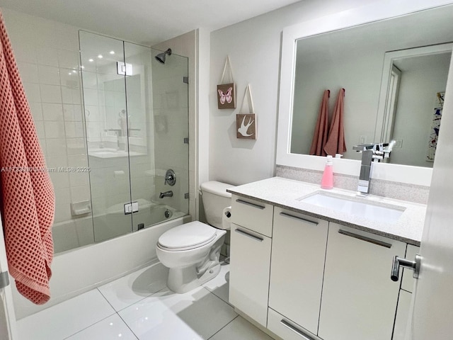 full bathroom with tile patterned flooring, tiled shower / bath combo, toilet, and vanity