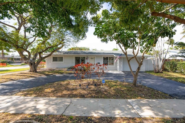 single story home with aphalt driveway and an attached garage