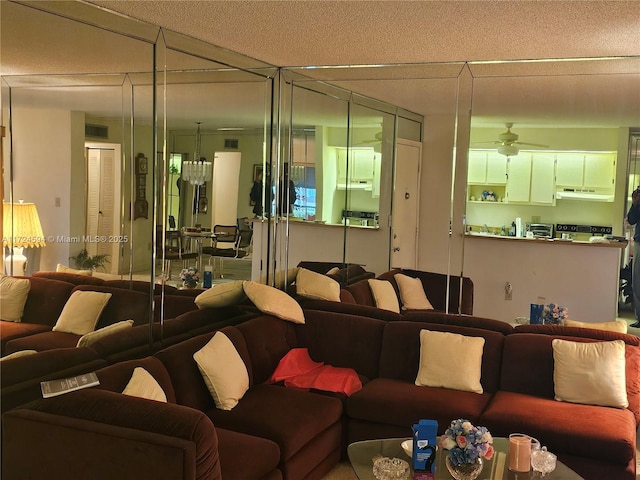 living room with a textured ceiling and ceiling fan