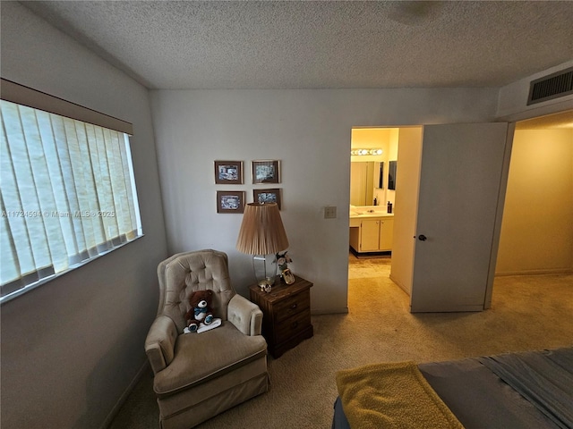 living area featuring light colored carpet and a textured ceiling