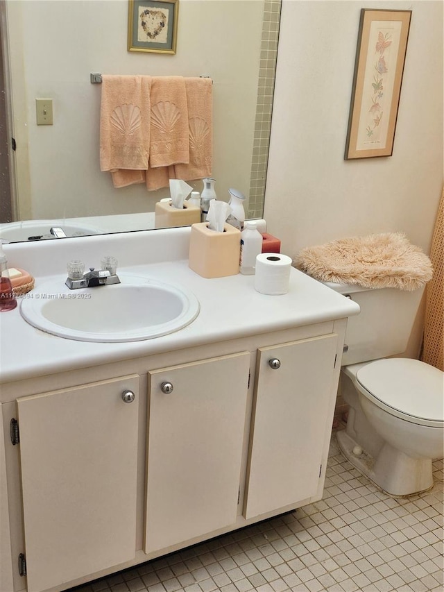 bathroom featuring toilet, vanity, and tile patterned flooring