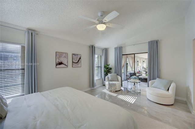 bedroom with baseboards, a textured ceiling, lofted ceiling, and ceiling fan