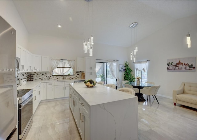 kitchen featuring a sink, high vaulted ceiling, stainless steel range with electric stovetop, and a center island