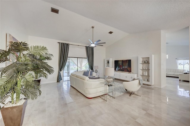 living area featuring a textured ceiling, a healthy amount of sunlight, visible vents, and ceiling fan