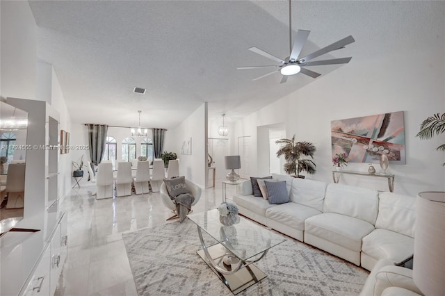 living area featuring visible vents, marble finish floor, ceiling fan with notable chandelier, a textured ceiling, and lofted ceiling