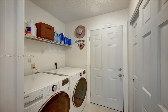 laundry room with laundry area, independent washer and dryer, and a textured ceiling