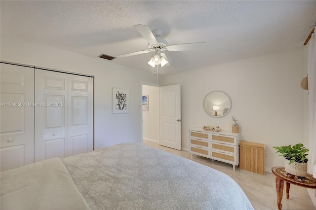 bedroom with visible vents, a textured ceiling, a closet, light wood finished floors, and ceiling fan