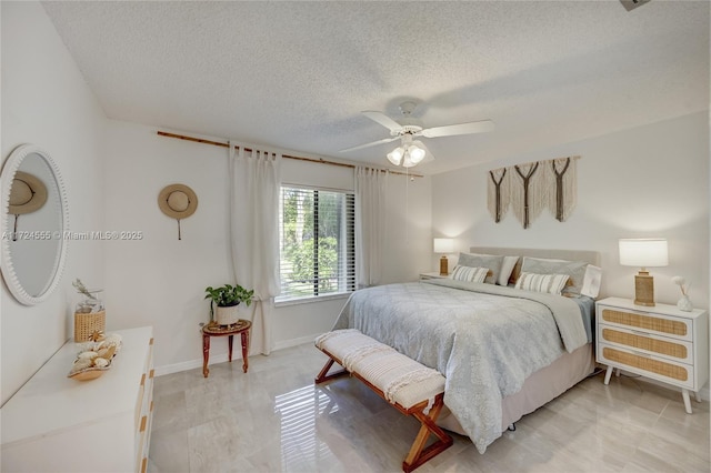 bedroom featuring baseboards, a textured ceiling, and a ceiling fan