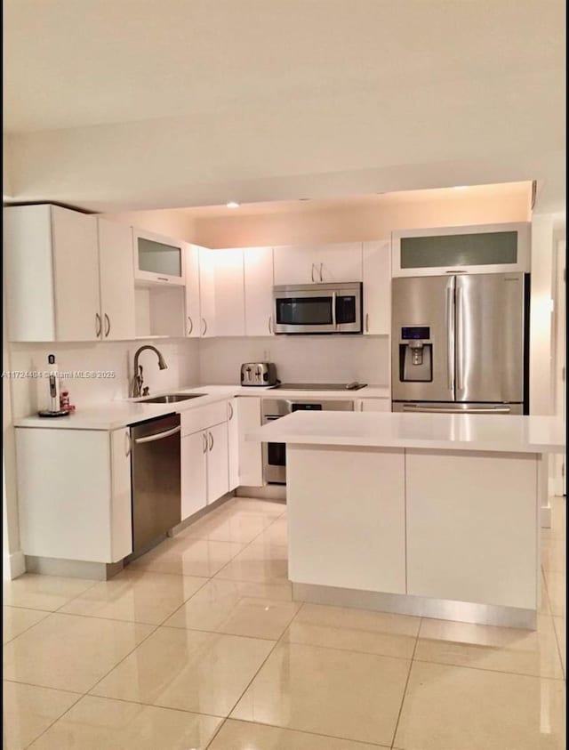 kitchen featuring light tile patterned flooring, sink, white cabinetry, and stainless steel appliances