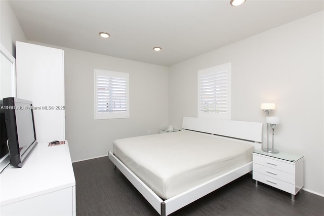 bedroom featuring multiple windows and dark hardwood / wood-style floors