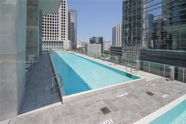 pool with a patio area and a view of city