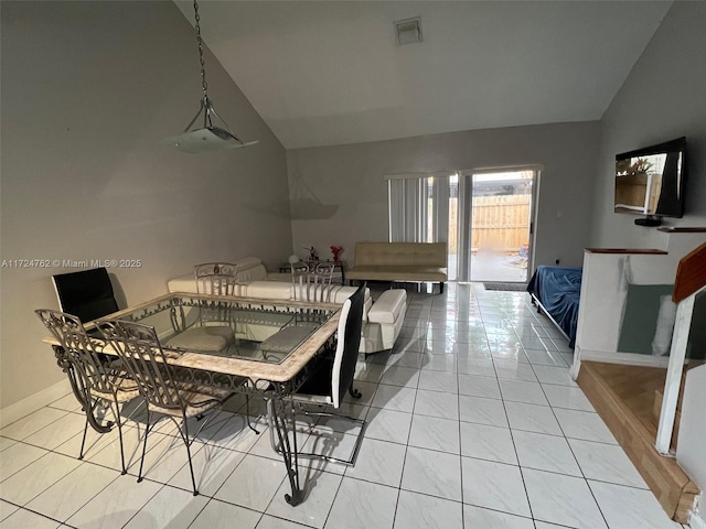 dining area with light tile patterned floors and lofted ceiling