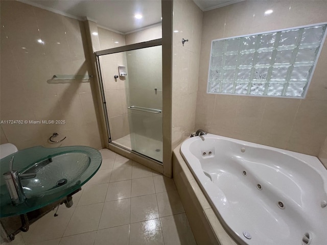 full bathroom with a tub with jets, a stall shower, tile walls, and tile patterned floors