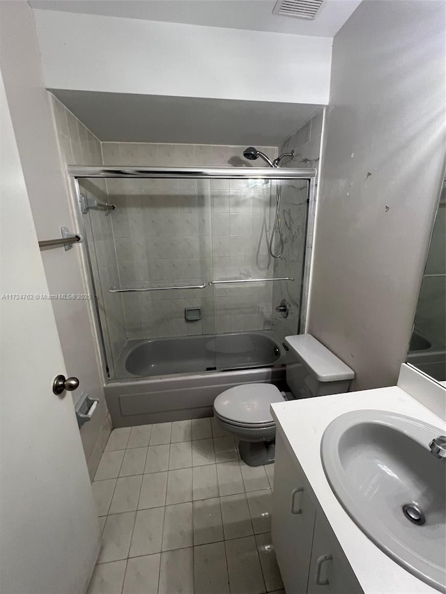 bathroom featuring enclosed tub / shower combo, toilet, visible vents, vanity, and tile patterned floors