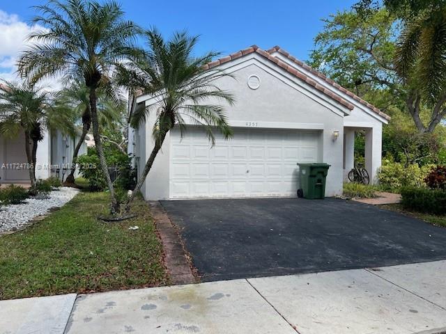 4357 Magnolia Ridge Dr, Weston, FL 33331 - view of property exterior with asphalt driveway, stucco siding, and an attached garage