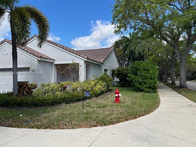 4357 Magnolia Ridge Dr, Weston, FL 33331 - view of property exterior featuring a tile roof, stucco siding, and a yard