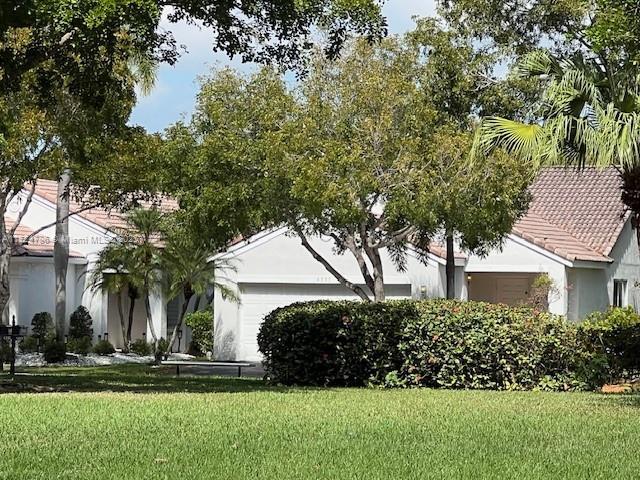 4357 Magnolia Ridge Dr, Weston, FL 33331 - view of front of property with a garage, a front yard, stucco siding, and a tiled roof