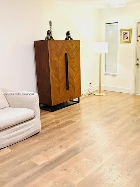 sitting room featuring light wood-style flooring and baseboards