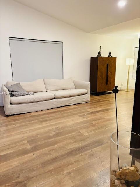 living area featuring lofted ceiling and wood finished floors