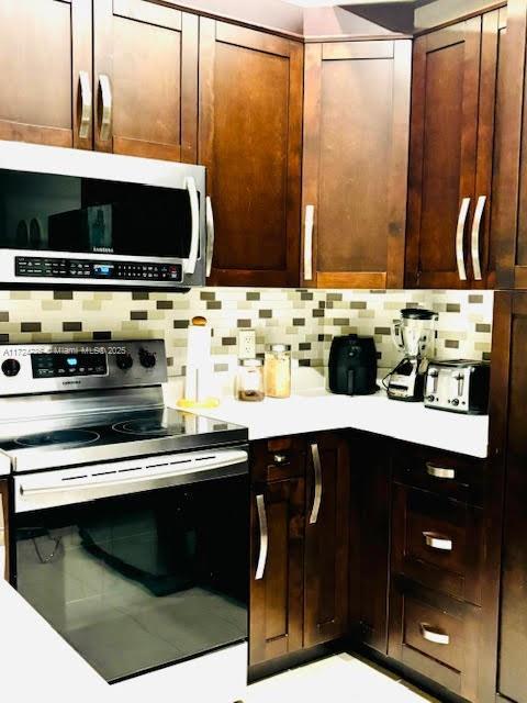 kitchen with appliances with stainless steel finishes and backsplash