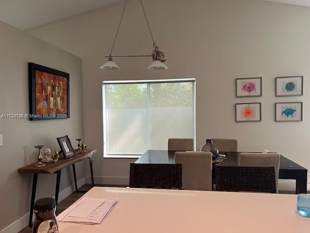 dining space with plenty of natural light, baseboards, and vaulted ceiling