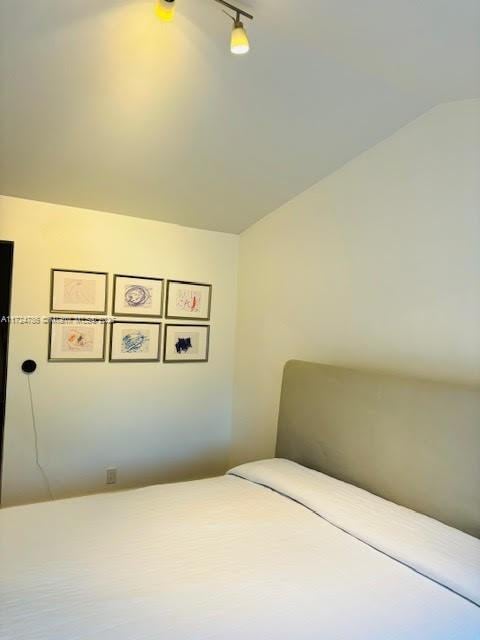 bedroom with lofted ceiling and rail lighting