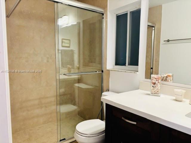 full bathroom with vanity, toilet, and a stall shower