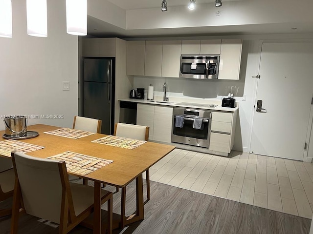 kitchen featuring sink, light hardwood / wood-style flooring, and black appliances