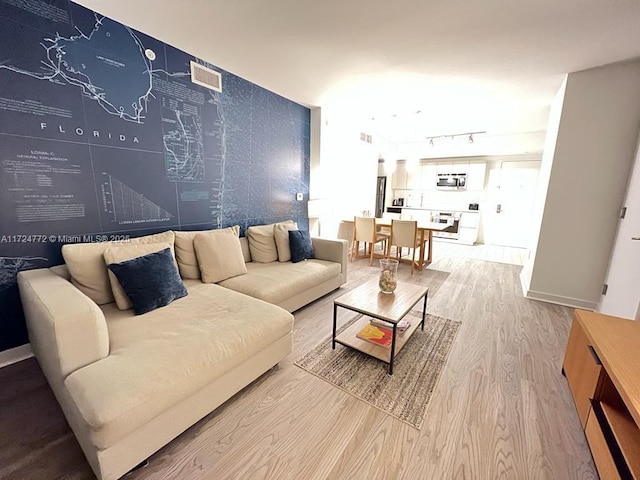 living room with wood-type flooring and rail lighting