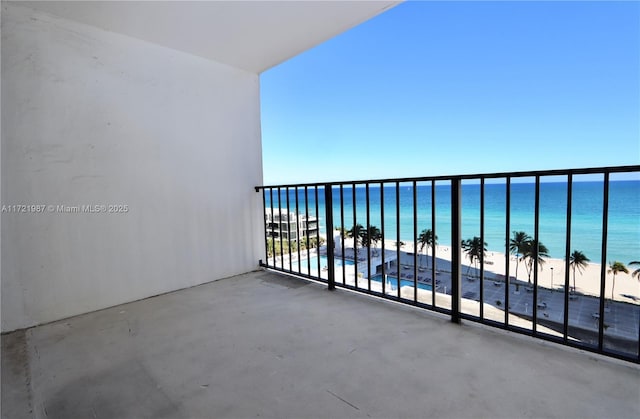 balcony featuring a view of the beach, a water view, and a patio area