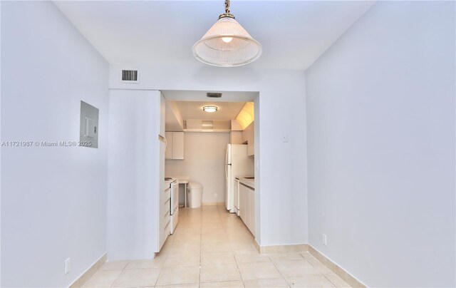 kitchen with light tile patterned flooring, white appliances, white cabinetry, and sink