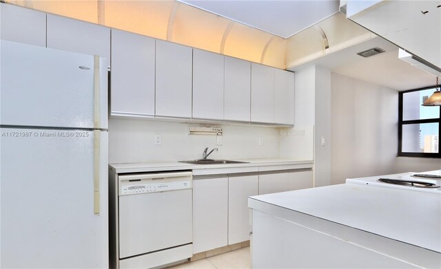 kitchen with white cabinets, white appliances, sink, and light tile patterned floors