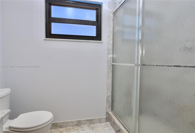 bathroom featuring vanity, toilet, and a shower with shower door