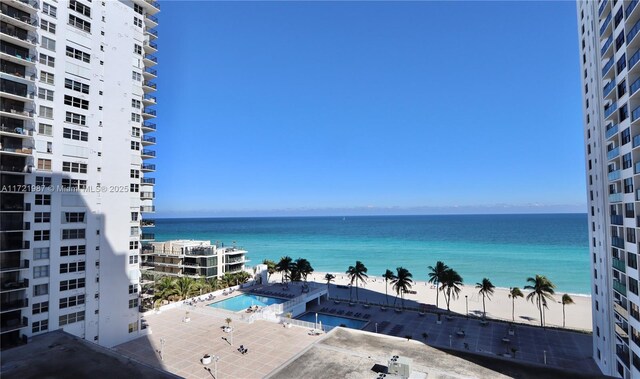 view of pool with a water view and a view of the beach