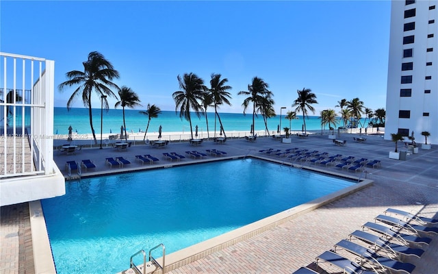 view of pool with a water view and a patio