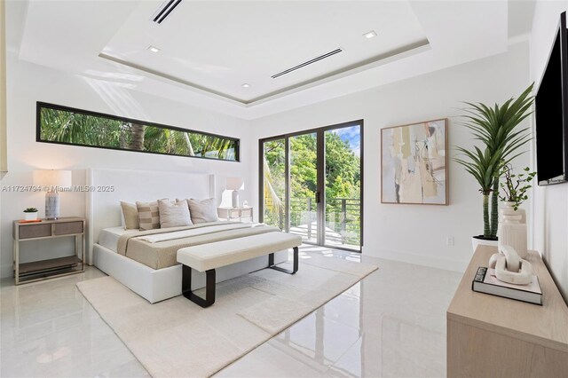 bedroom with access to outside and a tray ceiling