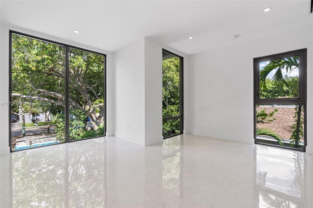 unfurnished room with expansive windows